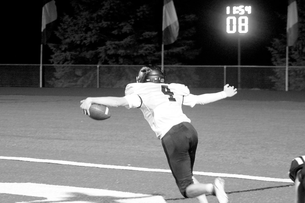 Clarke Latcham, shown scoring a touchdown against Williamsburg, was named the 2020 Mid-Prairie Addison Powell Student Athlete Award winner.